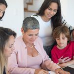 A family discusses real estate documents at home with a realtor, fostering communication and planning.